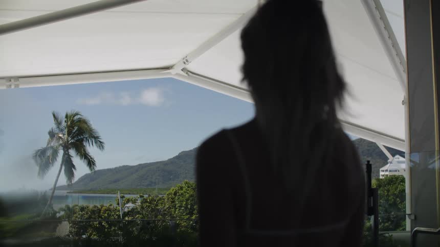 A woman walks toward the patio at a coastal resort
