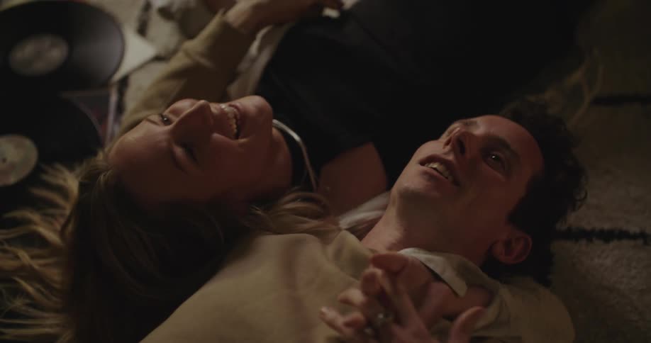 A young couple is laying down and being affectionate towards each other