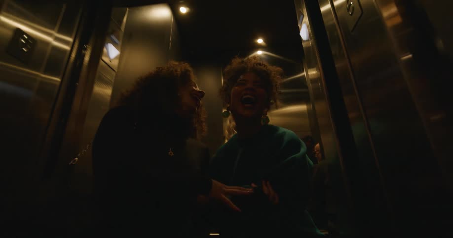 Women get off the elevator laughing