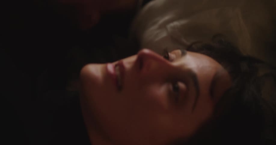 Two women chat while lying side by side on the floor