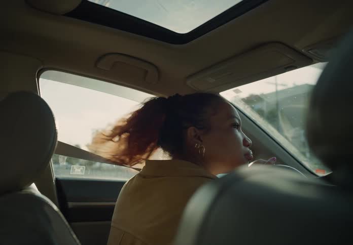 A woman driving her car looking back and forth at an intersection