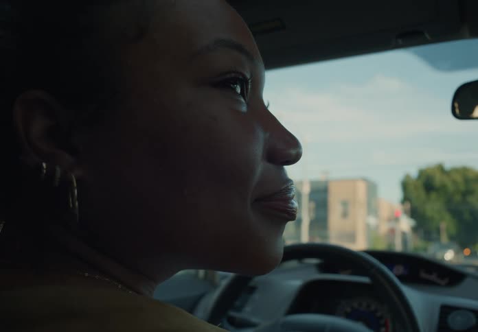 Mother sitting in drivers side of parked car probably waiting for kids