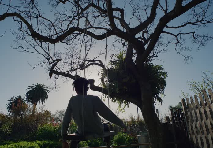 A boy is sitting on the swing