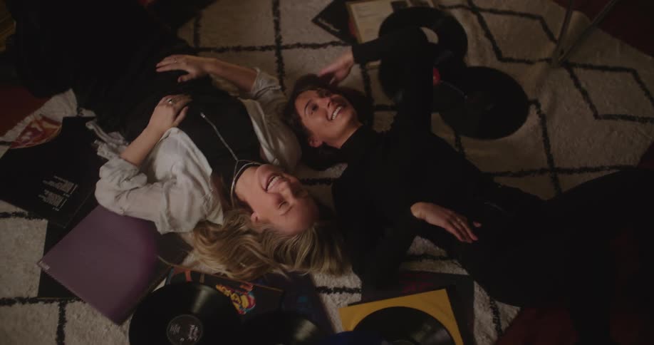 Two women lay on the floor talking