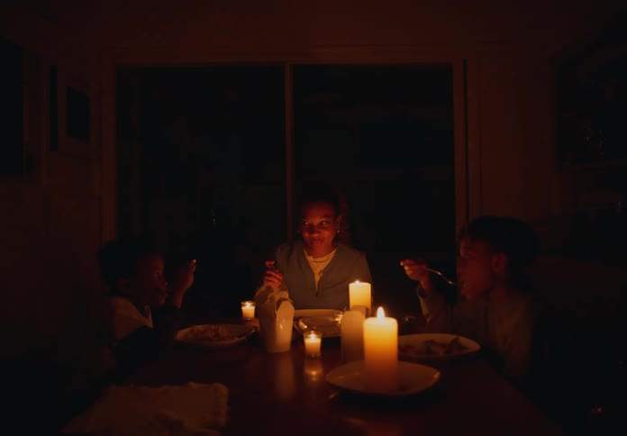 Family eating dinner at home at candle light during a blackout at night