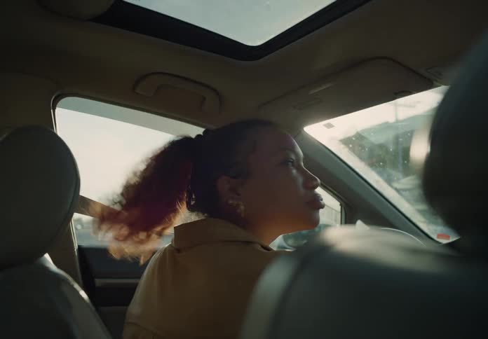 Woman pulling out of parking space or into intersection looking both ways several times and proceeds
