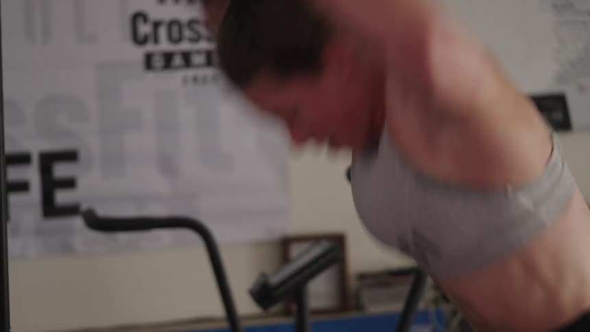 Woman training hard for crossfit using fitness gear in a gym