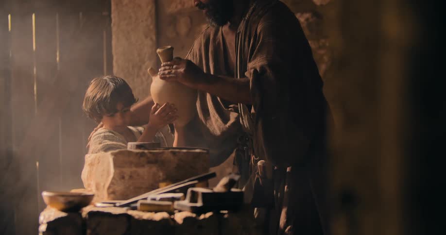 Boy brings a vase to a traditional middle east stonemason for him to have a drink