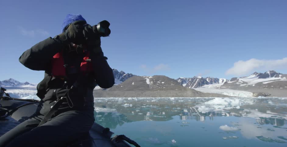 A woman takes a photograph while riding on a raft