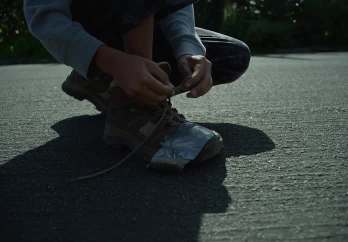 A boy ties his shoes
