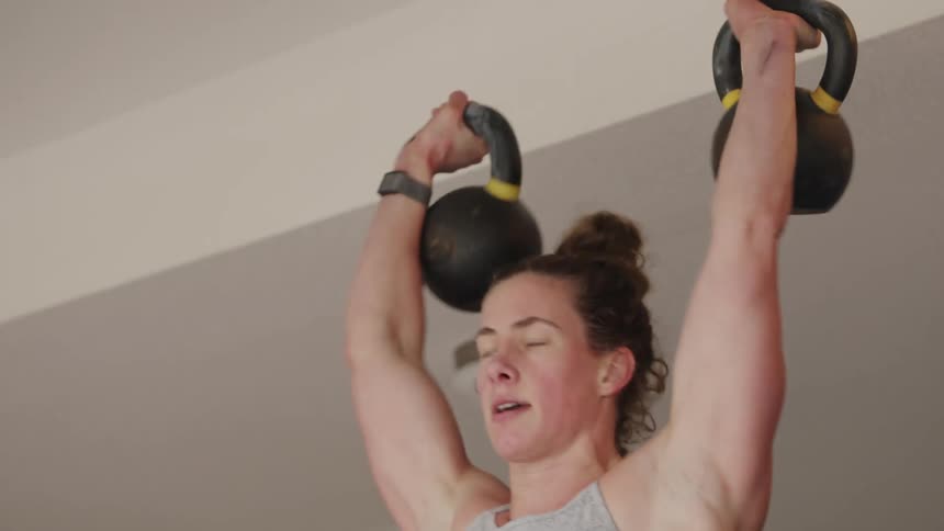 Woman lifts hand weights in a garage home gym