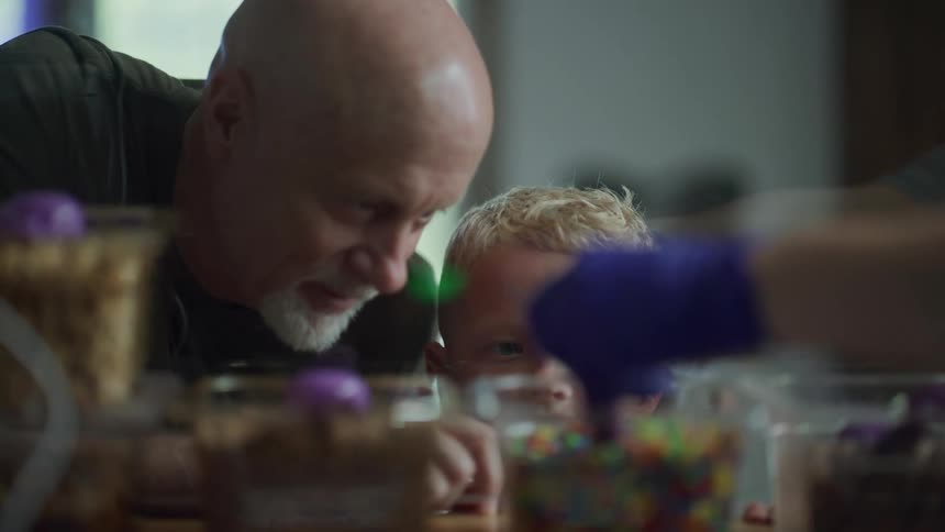 A man and boy look at the ice cream toppings