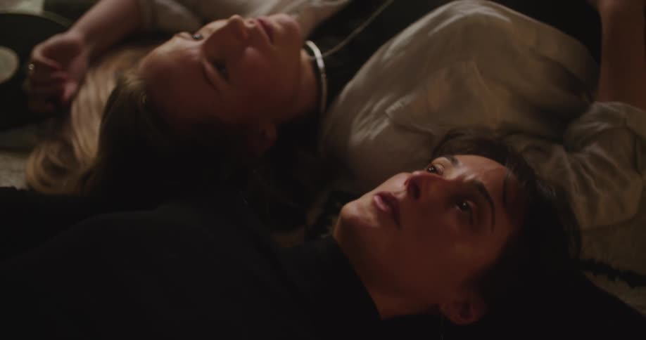 Two women talk while laying on the ground