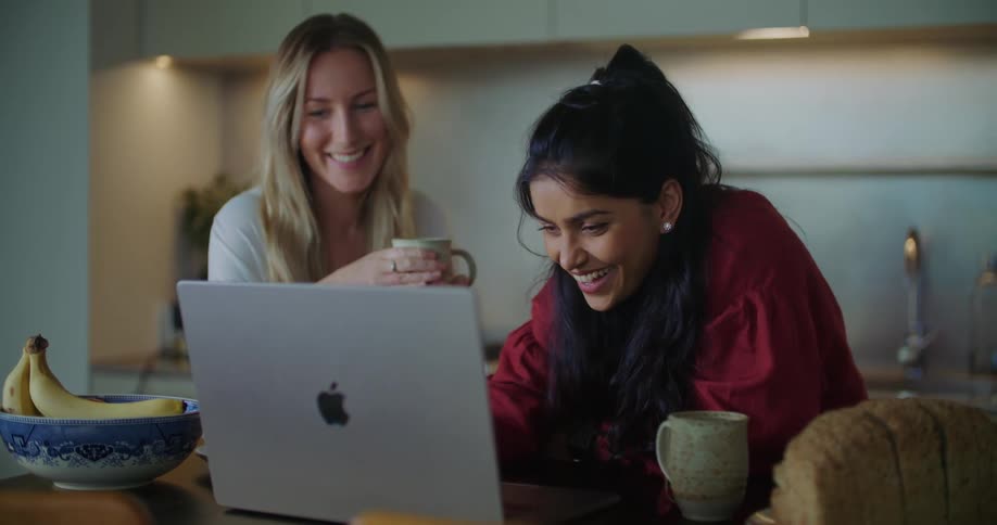 Two women look at a laptop and talk