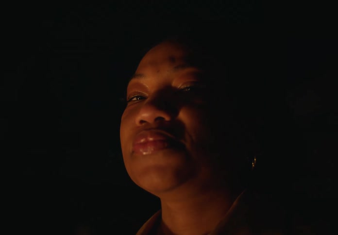 Woman standing inside a dark room during a blackout looking at the camera