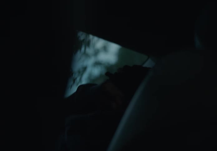A child puts on a hoodie in the car