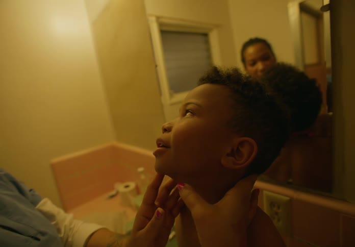 Mother carefully inspect the hair of her son over the bathroom sink at home
