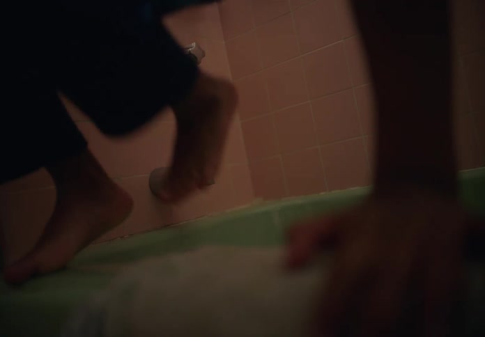 A child is climbing out of a bathtub