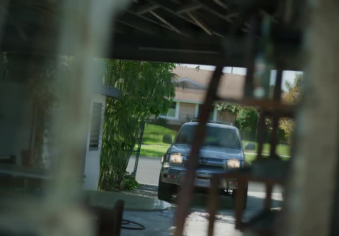 A man getting into a car and driving away