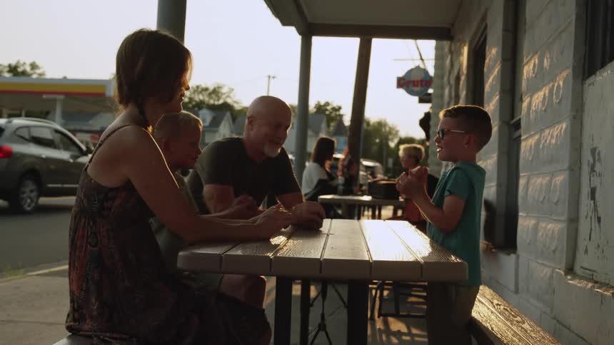 A family sit outside in town