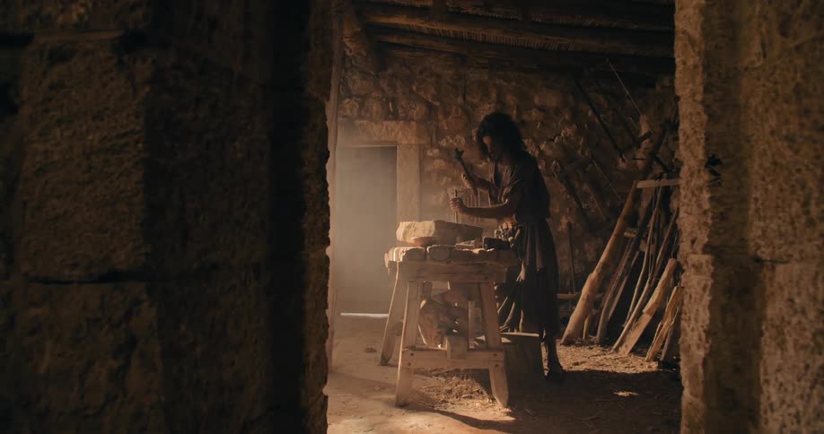 Traditional middle east stonemason carving a rock with hammer and chisel