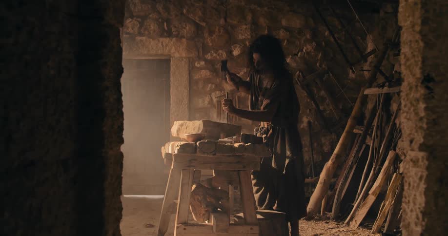 Traditional middle east stonemason carving a rock with hammer and chisel