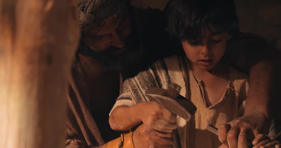 A father is teaching his son how to carve rocks
