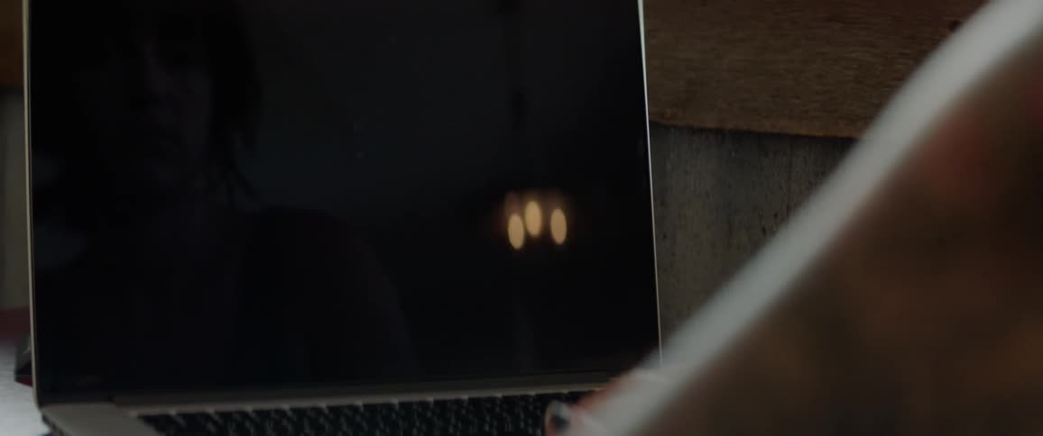 A person types on a laptop indoors