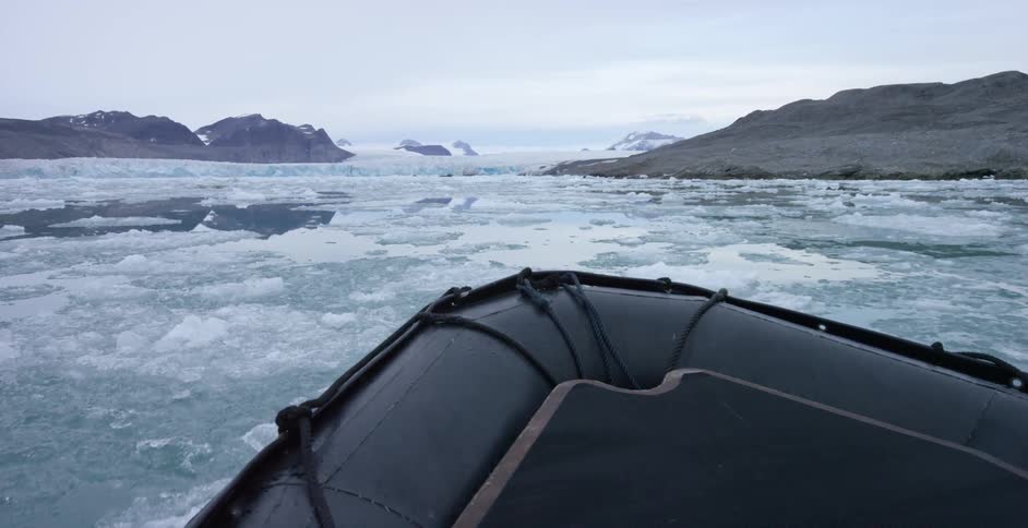 A rubber boat moves through ice flows