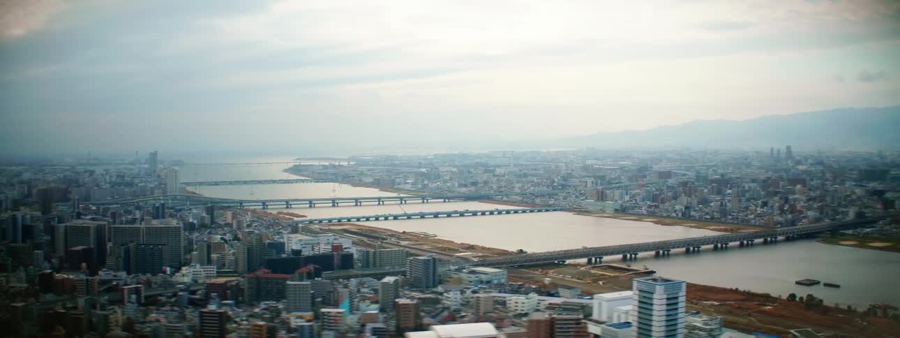A city with buildings a river and bridges with the sky and clouds in the background