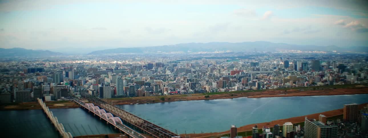 A river through a vast metropolis under a bright daytime sky