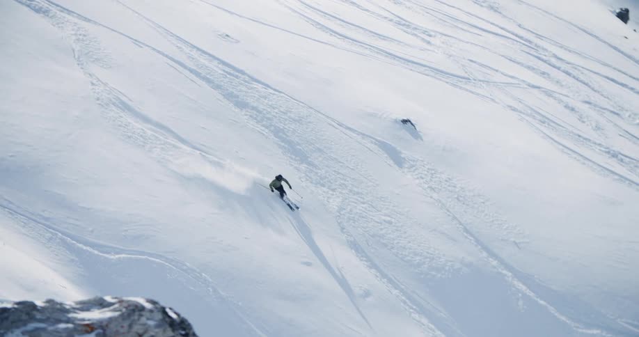 A skier goes down the side of a mountain
