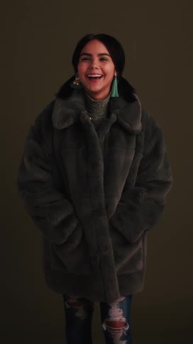 A teenager laughs and smiles as she models for a photoshoot
