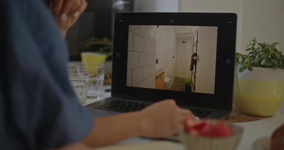 A woman looks at furniture and interior designs on the screen of her laptop computer