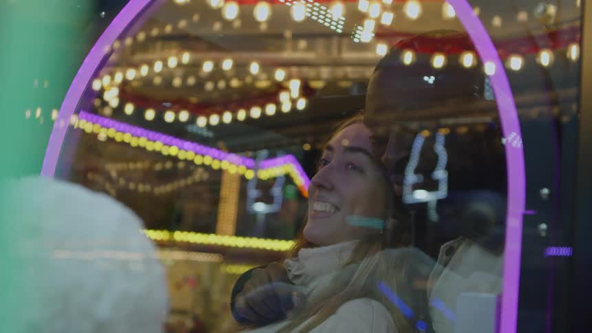 A man and woman smile as they play a carnival game with each other