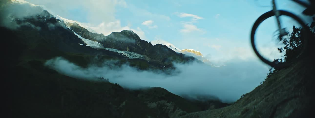 Thrilling Mountain Bikers Descend with Majestic Silhouette