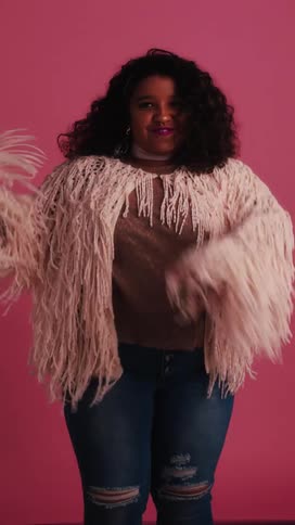 Black girl dances on a pink background