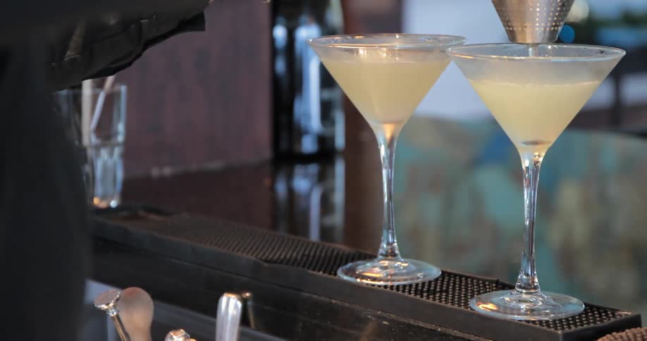 A woman is pouring drinks into glasses