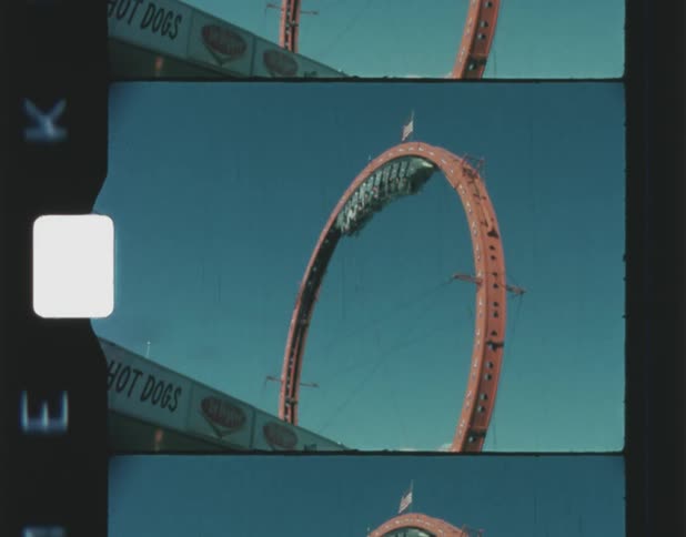 People ride a roller coaster as it loops and goes upside down