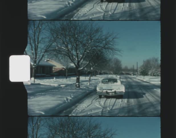 A neighborhood street covered in snow during the day