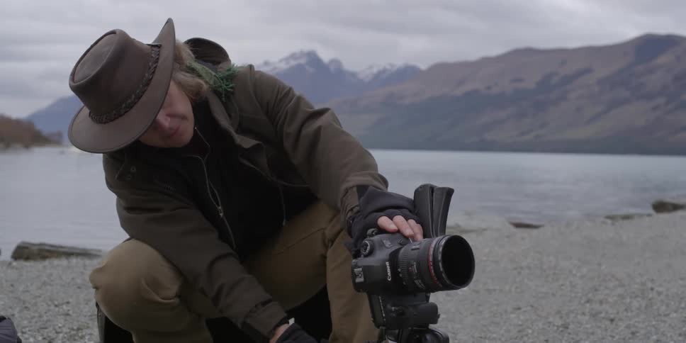 A person adjusts their camera outside
