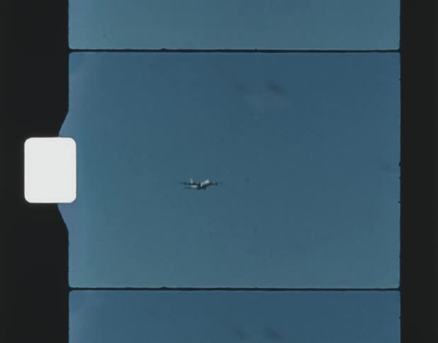 Film footage of an airplane flying in the clear sky