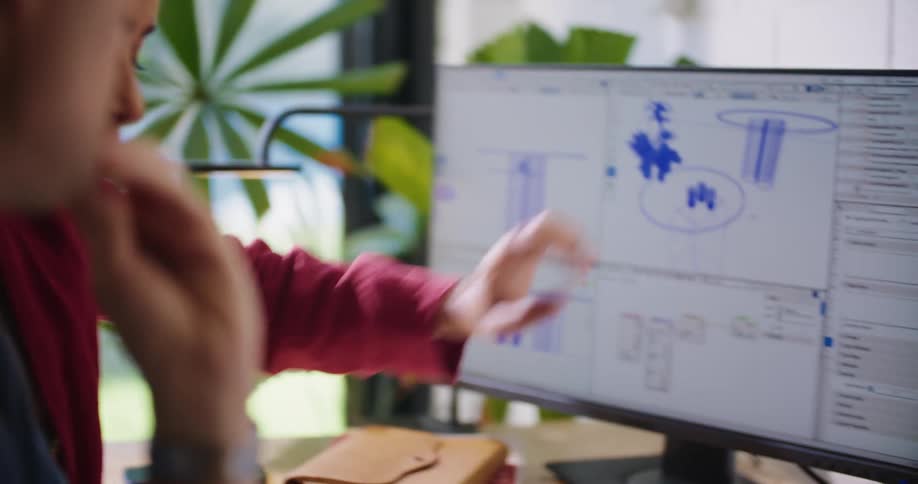 Two employees having a conversation while looking at a computer screen