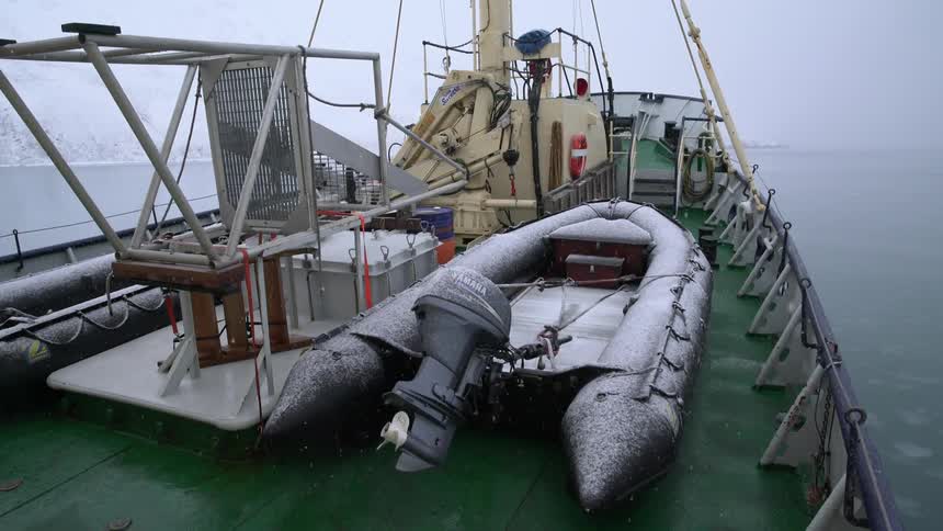 A raft sits on a ship as it snows