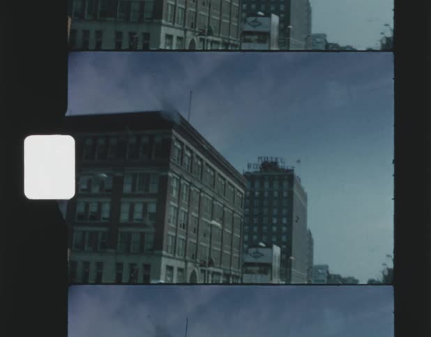 Cars are driving through a downtown city during midday