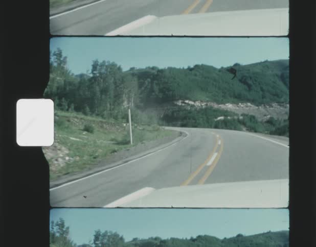 A vehicle drives down a rural highway