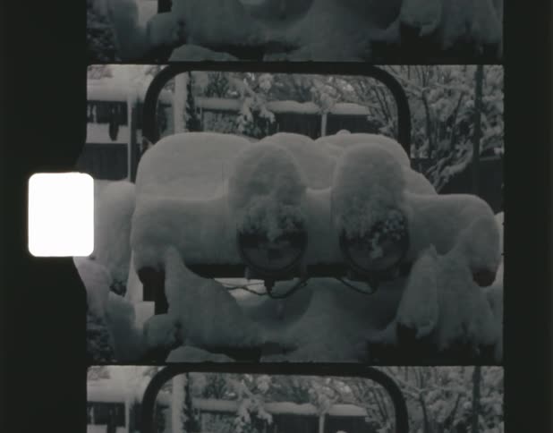 Deep snow covers plants and bushes as well as outdoor furniture on a winter day