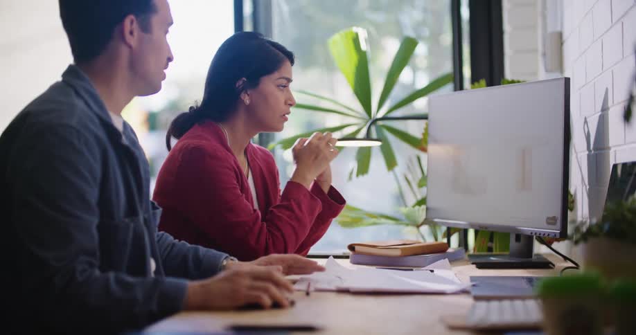 Man and woman are sitting in front of a computer screen