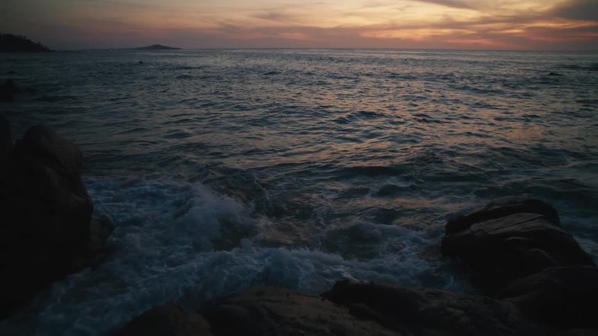 The sun is setting above the ocean water