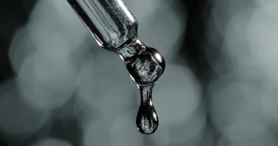Water dripping off a silver tool against a blurry background
